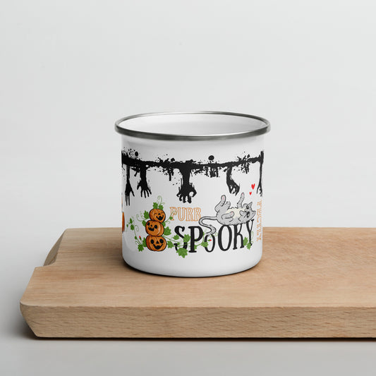 Illustrated enamel mug with zombie hands going through the top of the mug, while cats are playing. The words "Purr-fectly Spooky" are present on the mug, with smily pumpkins and vines.