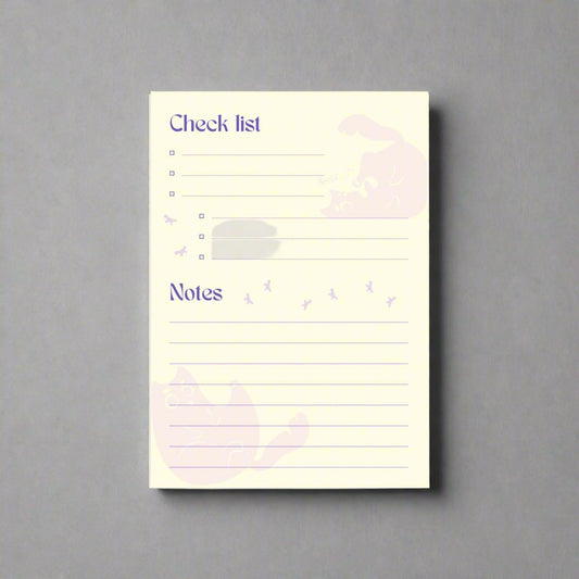 Light yellow notepad, featuring the black cat Squeekat. Enough place to jot down ideas and write priority list. This version is purple on a light yellow background.