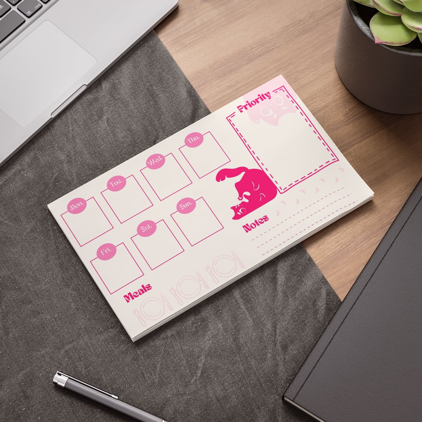 Pink Planner of Squeekat on a desk, with priority list, notes, weekly calendar and meals prep.