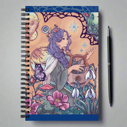 Spiral notebook with the illustration of an enchanted forest, phoenix and singing princess. The drawing is detailed and manga style. The warm color palette of the character brings a soft vibe to the green vegetation.