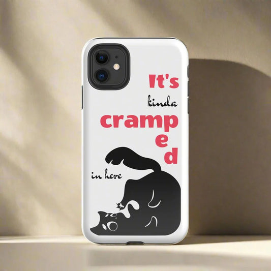 White phone case featuring a black cat trying to fit in the case corner. The funny words "It's kinda cramped in here" are present on the case. 