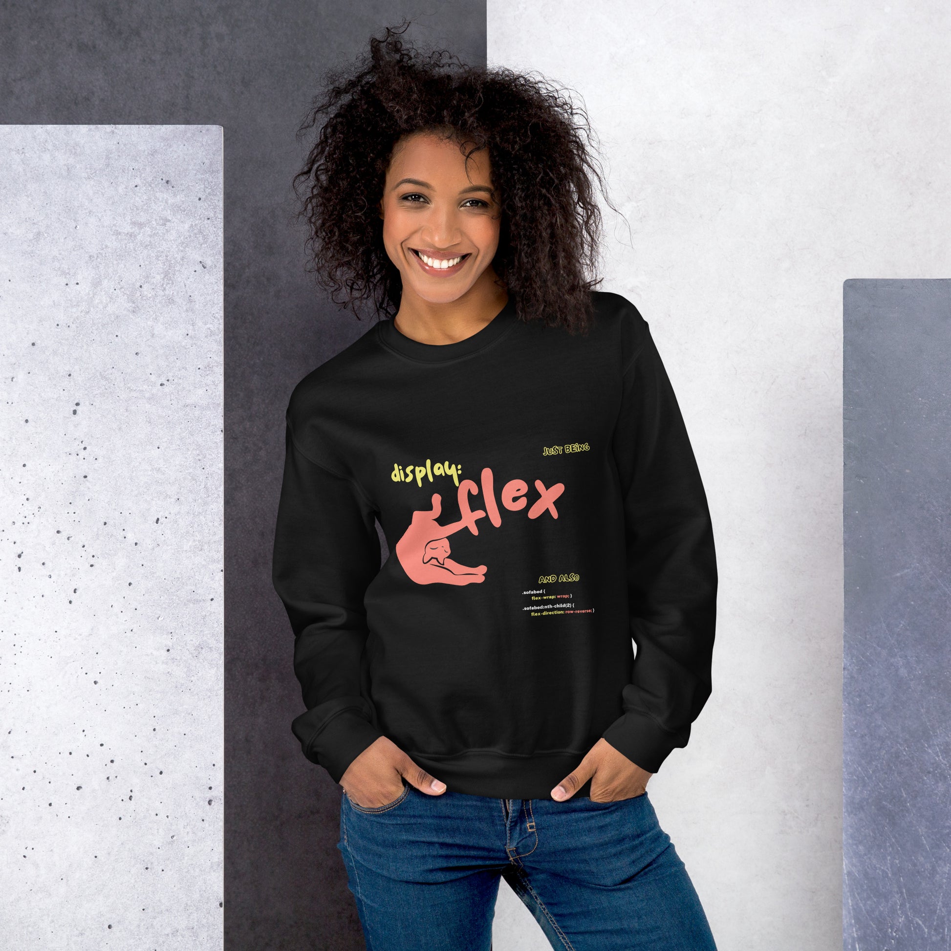 Woman wearing a black crew neck sweatshirt featuring a stretching cat with the title "Just bein' Display: flex". Funny pun about cat being flexible and the css command.