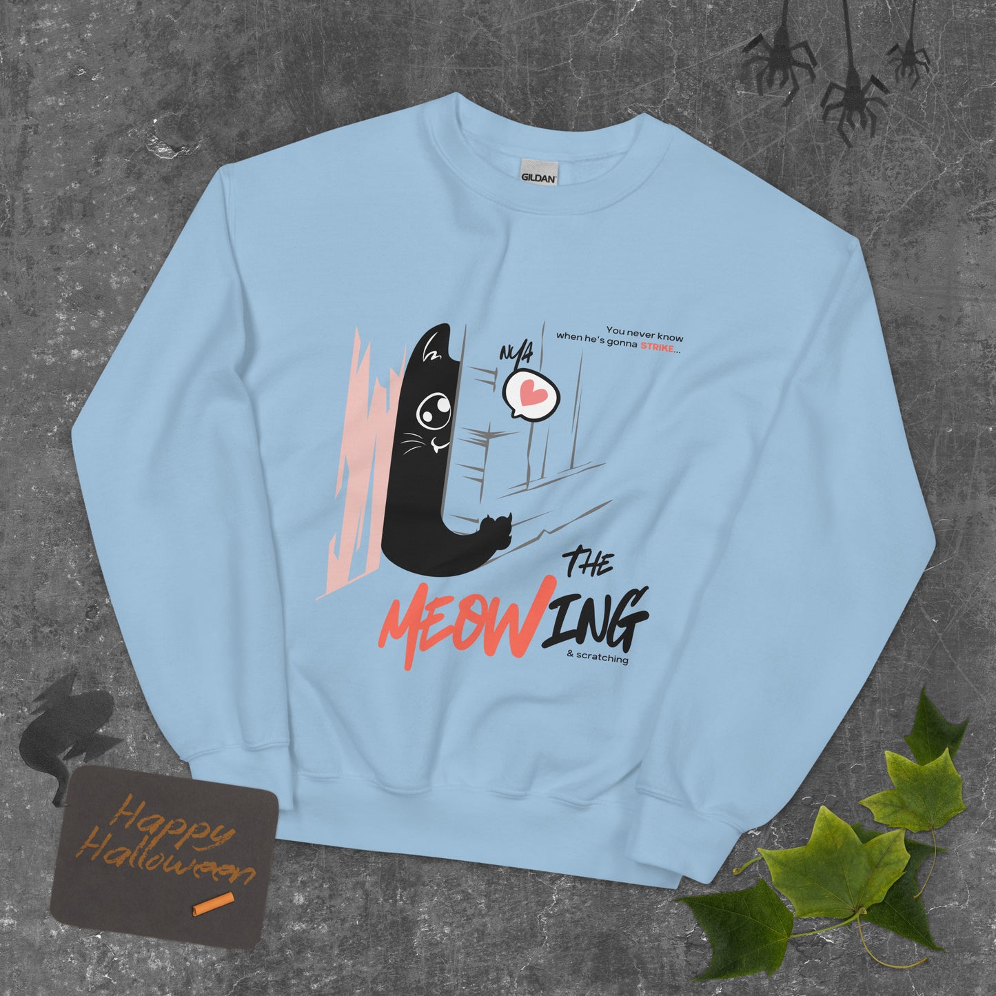 Light blue crew neck sweatshirt with illustration of a cat trying to break into a door. Parody of the Shining, this design is called "The Meowing & scratching" because you never know when he's gonna strike. This version shows a cute cat showing the finger while trying to enter the room.