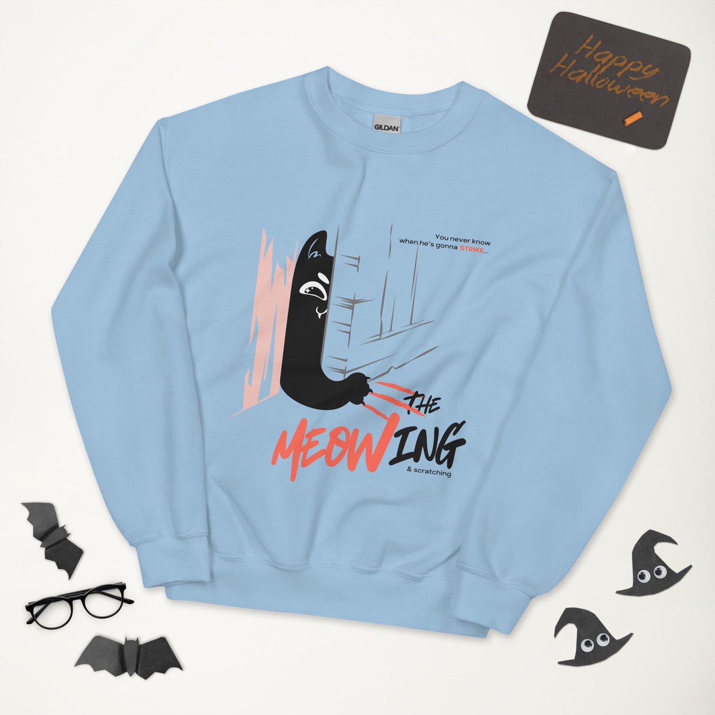 Light blue crew neck sweatshirt with illustration of a cat trying to break into a door. Parody of the Shining, this design is called "The Meowing & scratching" because you never know when he's gonna strike. This version shows a mischievous cat scratching the floor in an attempt to enter the room.