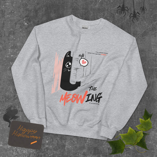 Light grey crew neck sweatshirt with illustration of a cat trying to break into a door. Parody of the Shining, this design is called "The Meowing & scratching" because you never know when he's gonna strike. This version shows a cute cat showing the finger while trying to enter the room.