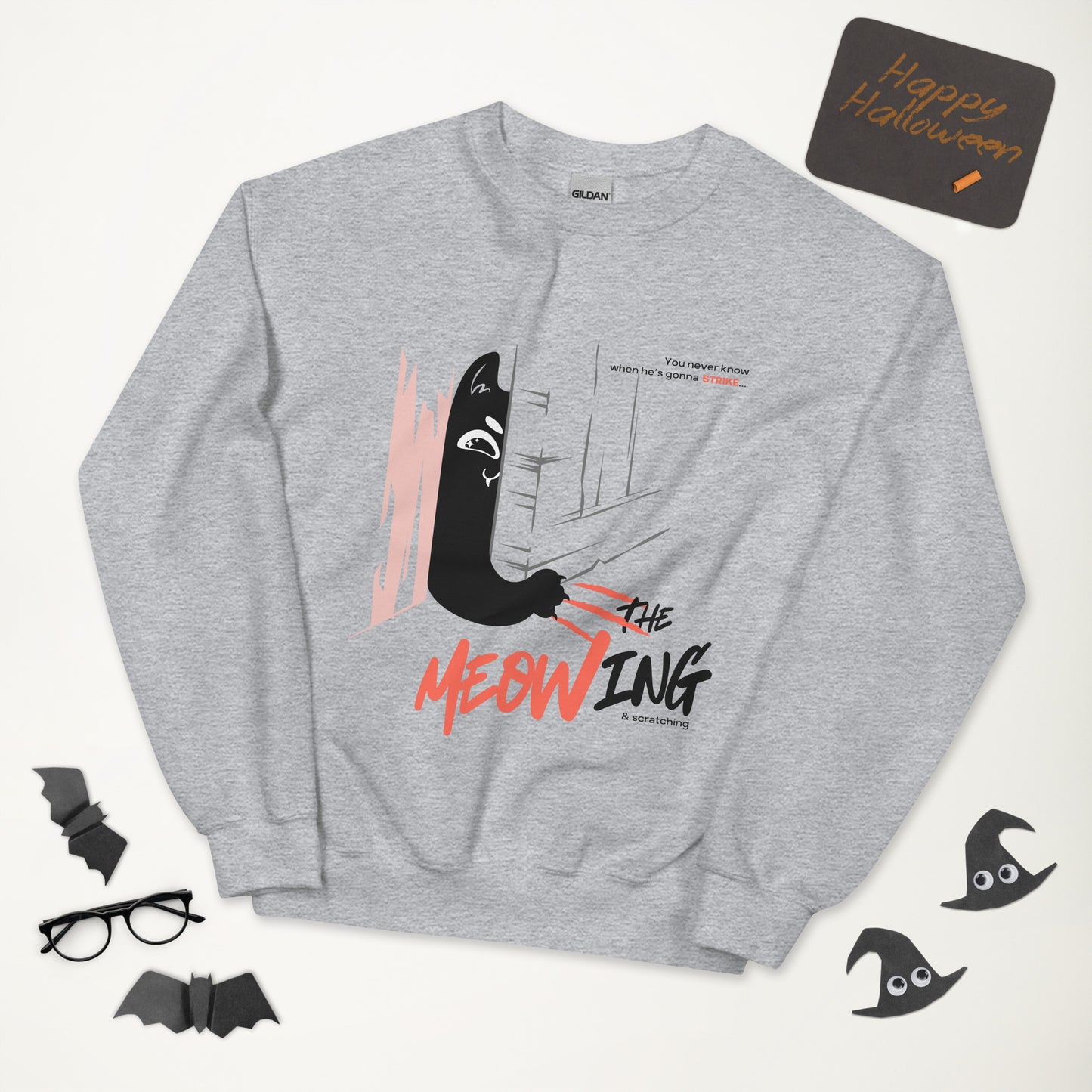 Light grey crew neck sweatshirt with illustration of a cat trying to break into a door. Parody of the Shining, this design is called "The Meowing & scratching" because you never know when he's gonna strike. This version shows a mischievous cat scratching the floor in an attempt to enter the room.