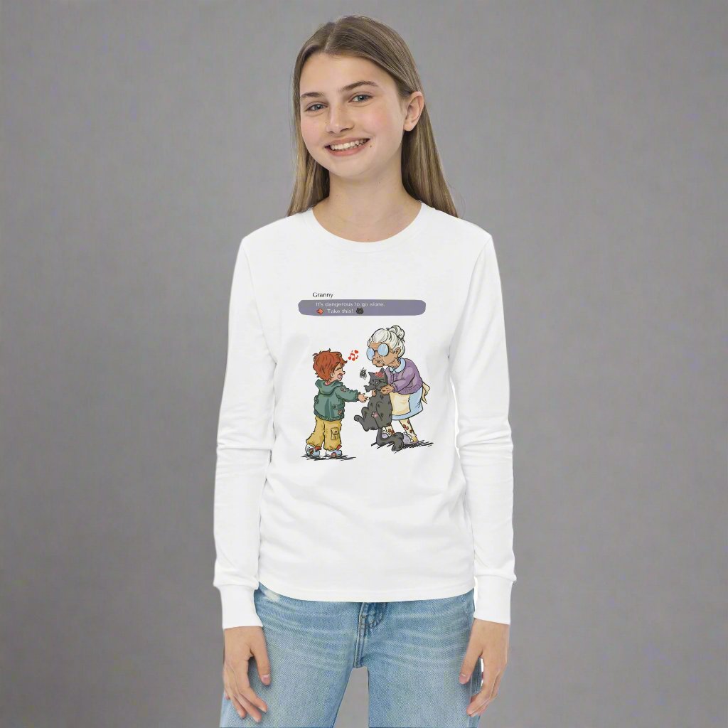 Young girl wearing a white long sleeved T-shirt with the illustration of a granny passing a grumpy cat to her way-to-happy grand-son. The discussion goes like "It's dangerous to go alone, Take this!" referring to the Zelda game.